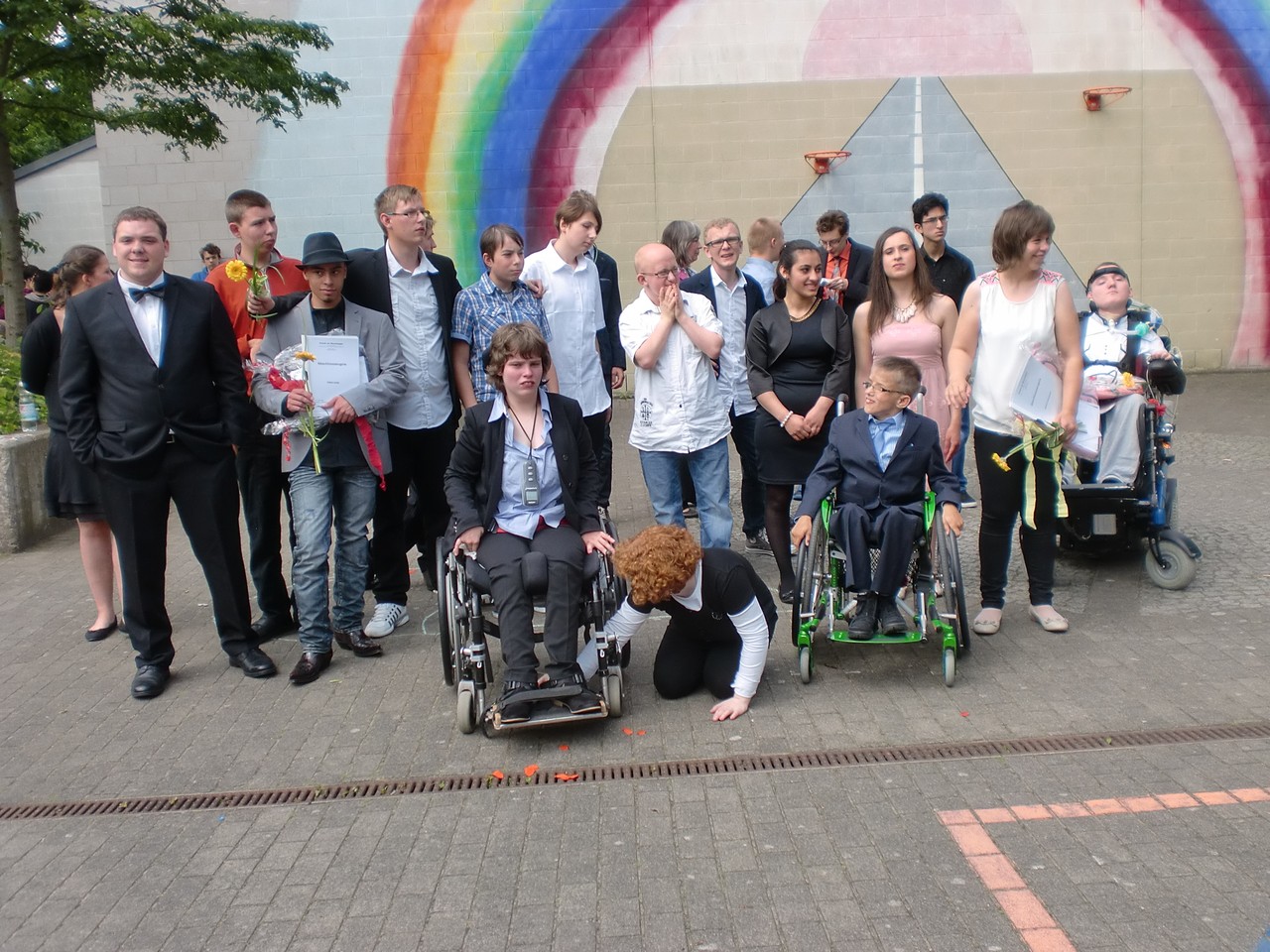 Alle Schülerinnen und Schüler auf einem Gruppenfoto vor dem Regenbogen