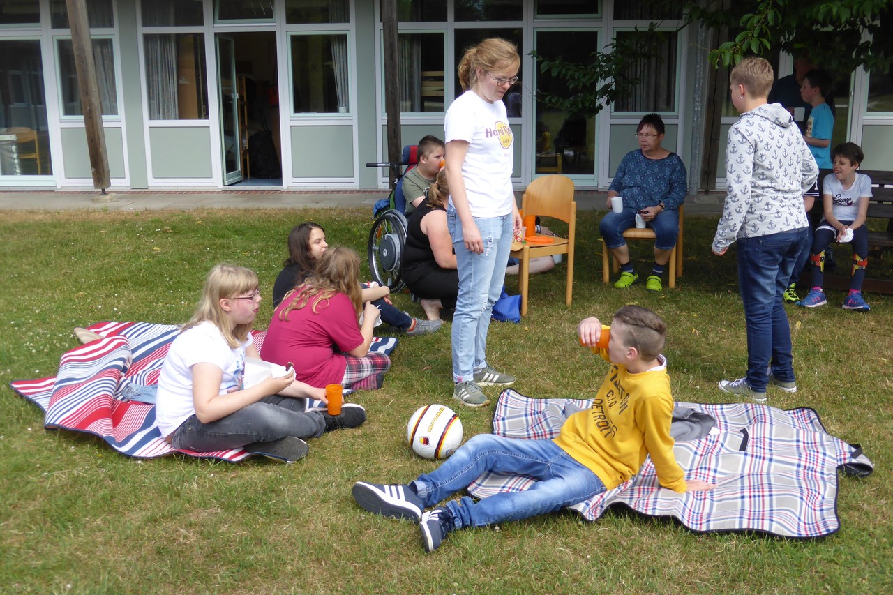 Die Schüler machen eine Trinkpause auf der Wiese