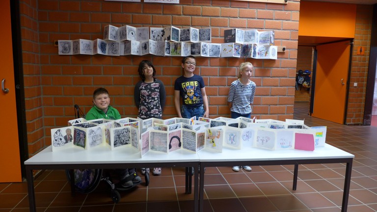 Einige Schülerinnen und Schüler der MIT A1 zeigen die Druckbücher beider Klassen.