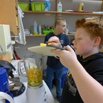 Schüler füllt einen Mixer mit zerkleinertem Obst für einen Smoothie (vergrößerte Bildansicht wird geöffnet)